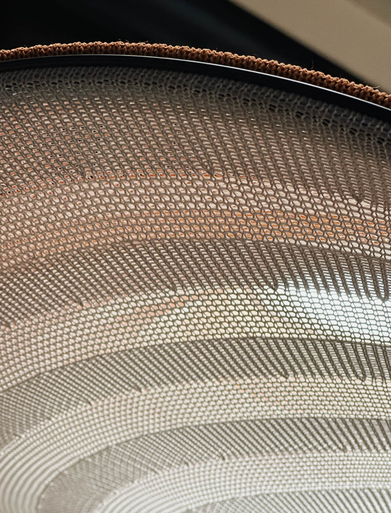 Underside of a 3D knitted lampshade: light passes subtly through the striped knit structure