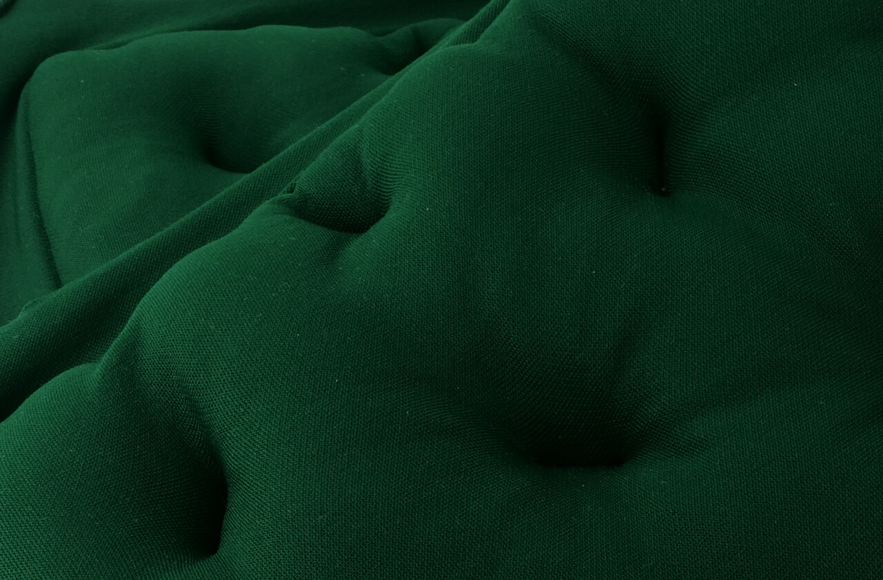 Nahaufnahme einer grünen 3D-gestrickten Textiloberfläche mit integrierter Füllstruktur für Akustikelemente im Innenraum