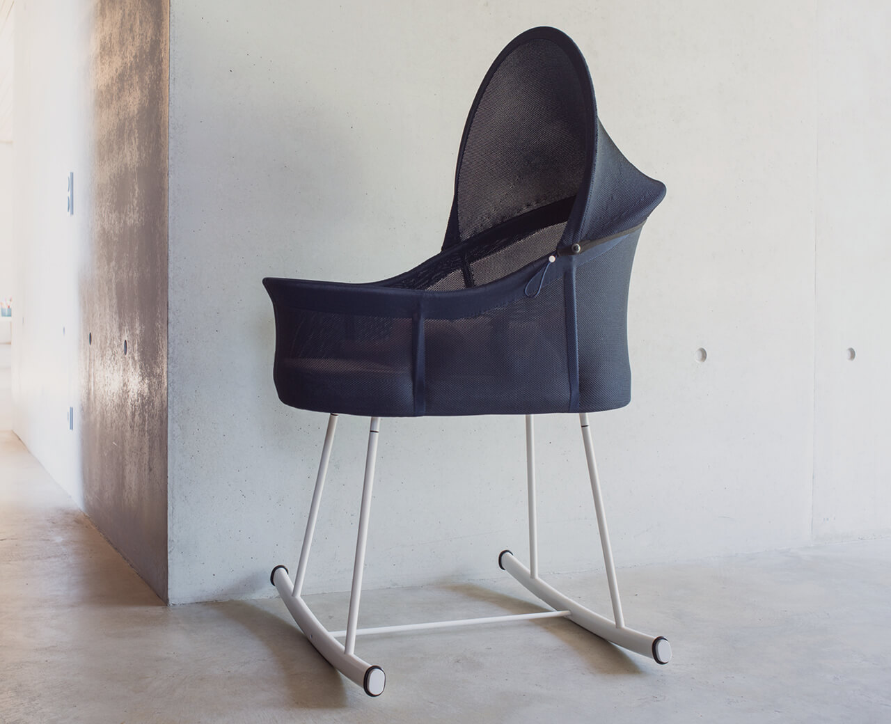 Rocking cradle combining a metal frame with a 3D knitted cover – minimal material, sustainable product design